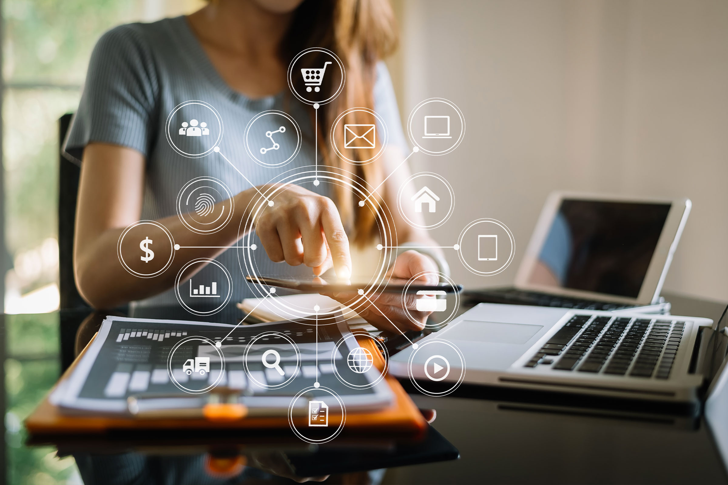 femme travaillant à son bureau avec ordinateur et smartphone et éléments digitaux